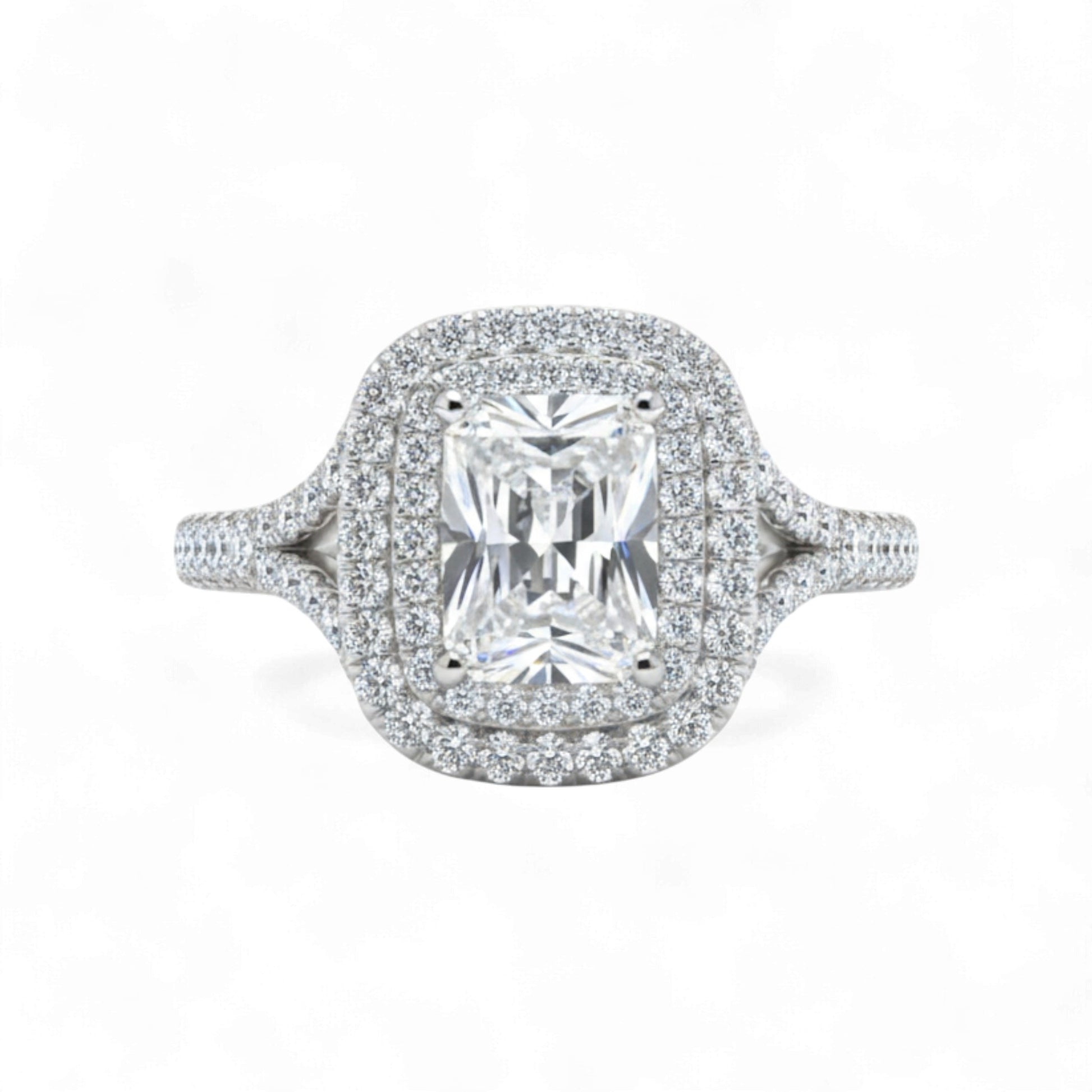 Diamond ring with a central gemstone and halo on a white background