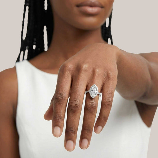 Woman wearing a diamond ring on her hand against a neutral background