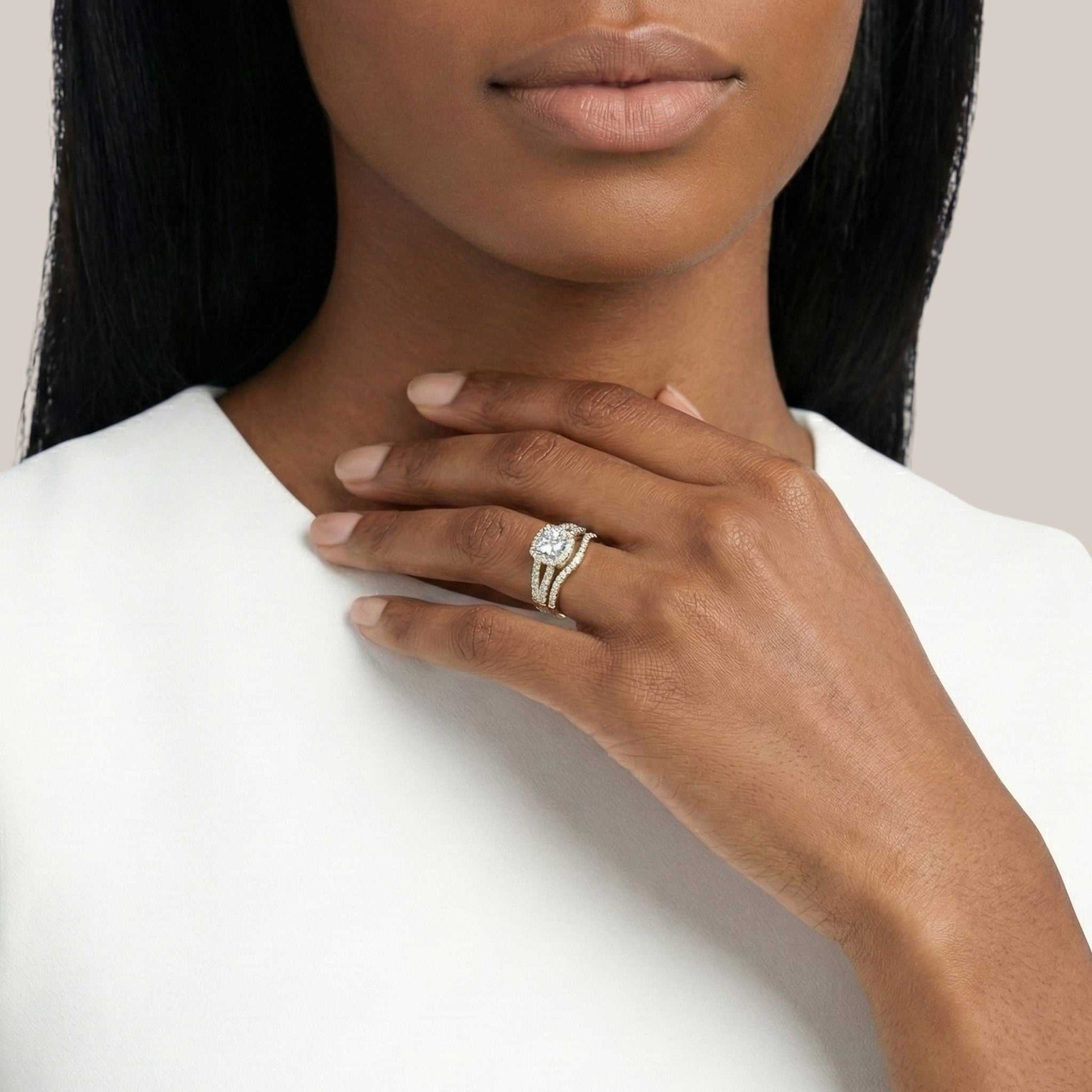Woman wearing a diamond ring on her hand against a plain background